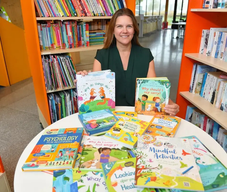 Natalie from Alconbury Weald Library recieving the books from David Wilson Homes